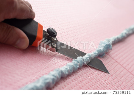 the master with a knife cuts off excess construction foam the master with a knife cuts off excess construction foam 75259111