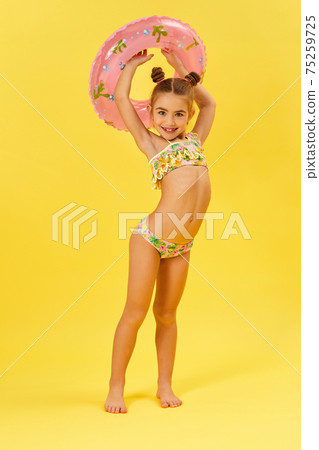 child girl in swimwear with inflatable rubber ring 75259725