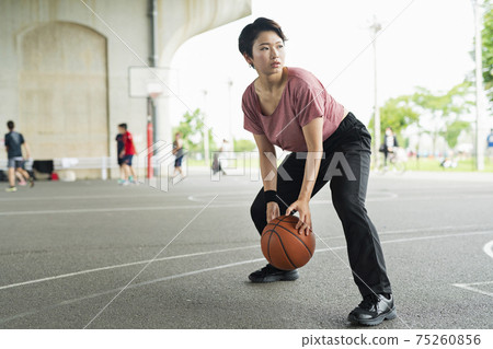A woman playing basketball A woman playing basketball 75260856