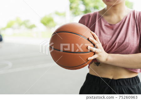 A woman playing basketball 75260963