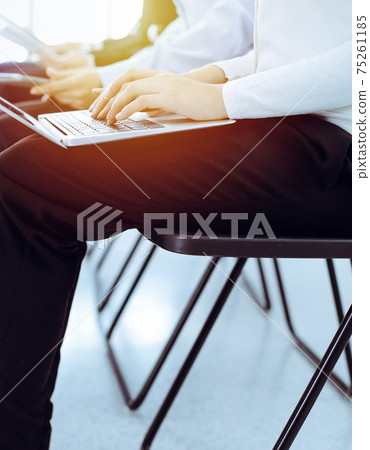 Group of diverse business people working in office, close-up. Woman working with laptop. Conference, meeting or training concepts Group of diverse business people working in office, close-up. Woman working with laptop. Conference, meeting or training concepts 75261185