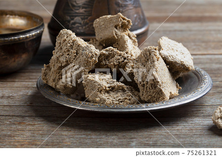 Vegetable-based halva sweet prepared from seeds on wooden background Vegetable-based halva sweet prepared from seeds on wooden background 75261321