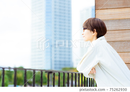 Woman looking at the scenery from the balcony Woman looking at the scenery from the balcony 75262930