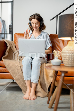 Woman working with laptop and headphones from home Woman working with laptop and headphones from home 75263795
