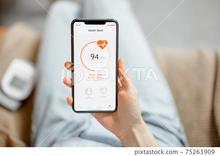 Woman showing a heart rate on smartphone Woman showing a heart rate on smartphone 75263909