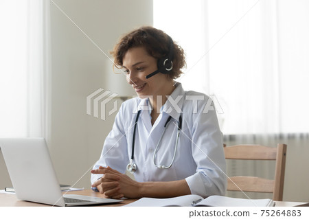 Smiling female doctor talk on video call on laptop Smiling female doctor talk on video call on laptop 75264883