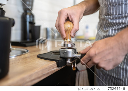 Male hands holding coffee machine filter holder 75265646