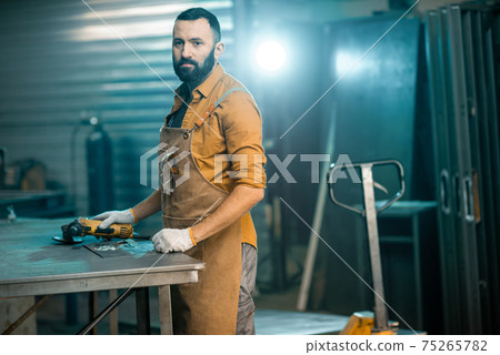 Man working with metal at the workshop 75265782