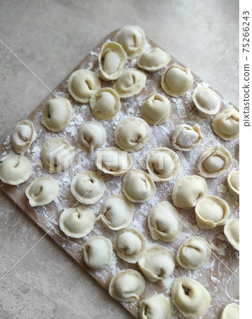 Traditional pelmeni or dumpling at cutting board. Homemade preparation food. Traditional pelmeni or dumpling at cutting board. Homemade preparation food. 75266243