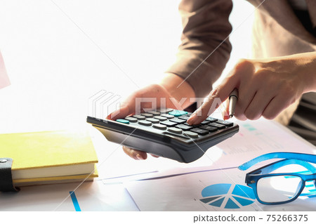Close up Accountant using calculator for calculating financial expense  75266375