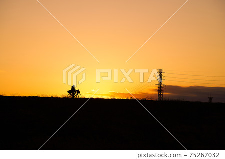 Bicycle running on the bank at dusk 75267032