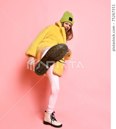 Bright rebellious girl kicks the camera while Bright rebellious girl kicks the camera while 75267351