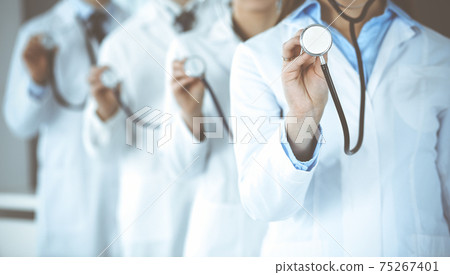 Group of doctors holding stethoscope head close-up. Physicians ready to examine and help patient. Medicine concept Group of doctors holding stethoscope head close-up. Physicians ready to examine and help patient. Medicine concept 75267401