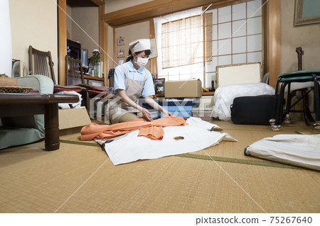 Female worker cleaning up a messy room Female worker cleaning up a messy room 75267640