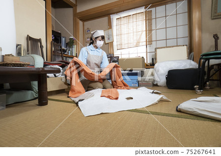 Female worker cleaning up a messy room Female worker cleaning up a messy room 75267641