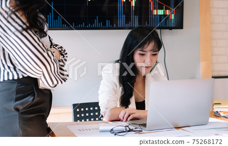 Business people meeting in office and discussing over a documents, two woman with a financial report with partner colleague on laptop computer Business people meeting in office and discussing over a documents, two woman with a financial report with partner colleague on laptop computer 75268172