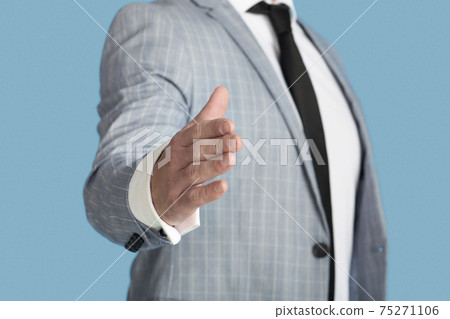 Untrecognizable young businessman offering hand for handshake on blue studio background, closeup Untrecognizable young businessman offering hand for handshake on blue studio background, closeup 75271106