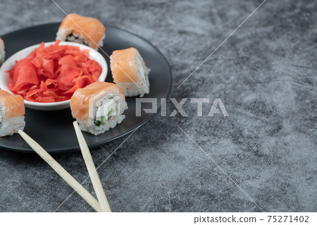 Salmon maki rolls in a white plate with red marinated ginger Salmon maki rolls in a white plate with red marinated ginger 75271402