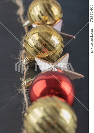 Colorful ornaments hanged from the rustic thread on the dark stone background 75271403