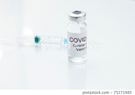 Vial with coronavirus vaccine for 2019-nCoV COVID-19 virus with syringe on glass background. Vial with coronavirus vaccine for 2019-nCoV COVID-19 virus with syringe on glass background. 75271985