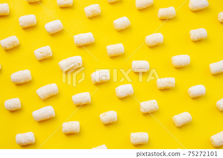 Background of air corn sticks pattern texture on yellow background 75272101