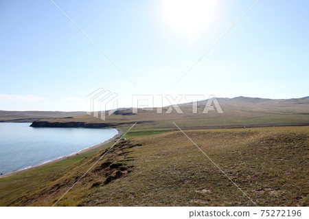 Beautiful view of Lake Baikal landscape with open spaces. View from high cliff. Island Olkhon. Clear summer day Beautiful view of Lake Baikal landscape with open spaces. View from high cliff. Island Olkhon. Clear summer day 75272196