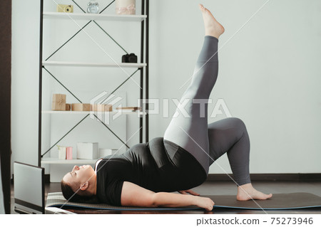 Overweight woman doing physical exercises at home Overweight woman doing physical exercises at home 75273946