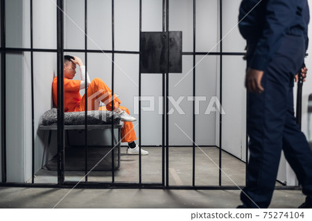 A male warden guards cells with dangerous criminals in a high-security prison. Dangerous profession. 75274104