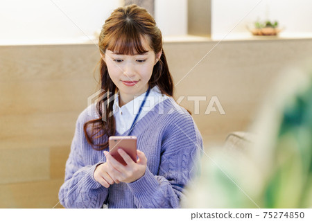 A business woman talking on a smartphone at a cafe A business woman talking on a smartphone at a cafe 75274850