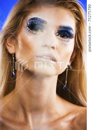 beauty young snow queen in fairy flashes with hair crown on her head close up in cold blue light 75275790