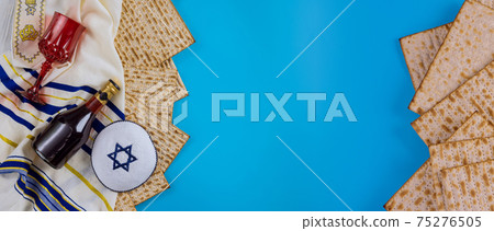 Jewish Passover attributes in composition a cup of wine and passover matzah Jewish Passover attributes in composition a cup of wine and passover matzah 75276505