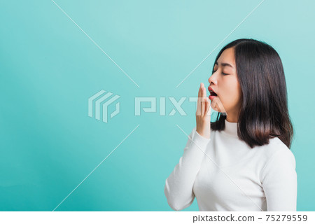 Portrait female bored yawning tired covering mouth with hand Portrait female bored yawning tired covering mouth with hand 75279559