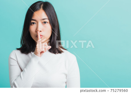 woman holding index finger on her mouth lips woman holding index finger on her mouth lips 75279560