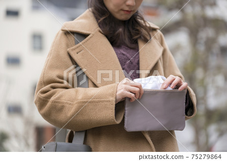 女人從口罩袋中取出口罩 女人從口罩袋中取出口罩 75279864