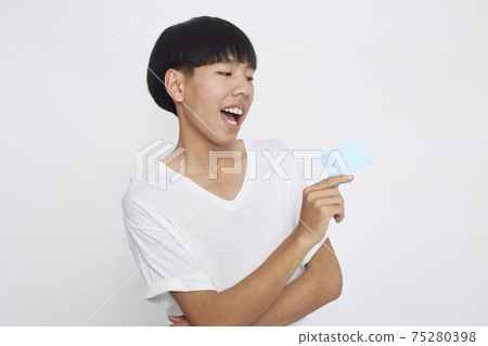 Asian man showing credit card Asian man showing credit card 75280398
