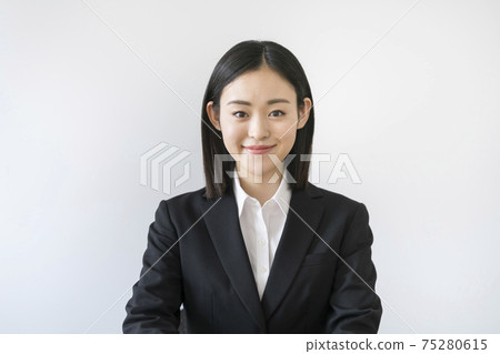 一個二十多歲的女人穿著西裝看著相機 一個二十多歲的女人穿著西裝看著相機 75280615