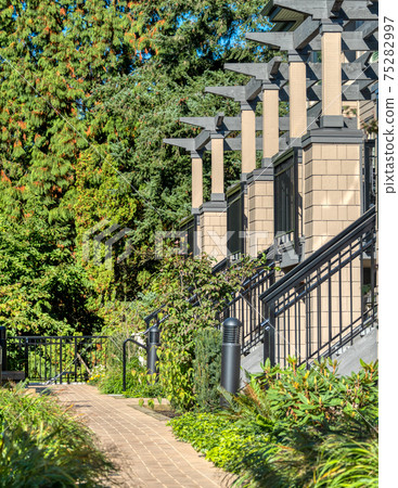 Porches of residential townhouses in a row with paved pathway in front 75282997