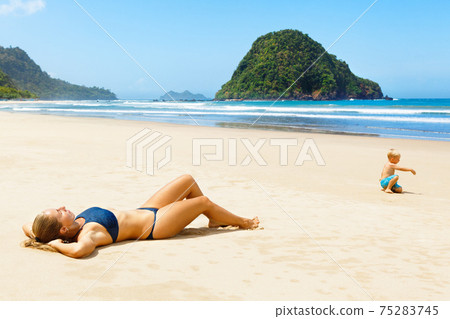 Happy young woman relax on tropical sand beach 75283745