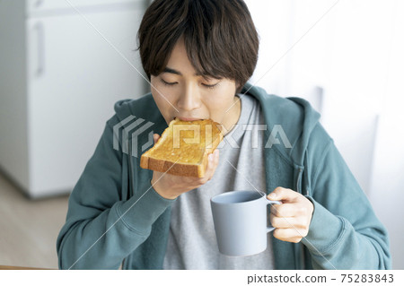 Young man eating toast 75283843
