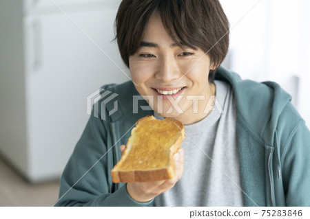 Young man eating toast 75283846
