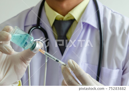 Doctors holding a syringe and a bottle of COVID-19 vaccine. Medical experimental vaccine treatment Doctors holding a syringe and a bottle of COVID-19 vaccine. Medical experimental vaccine treatment 75283882