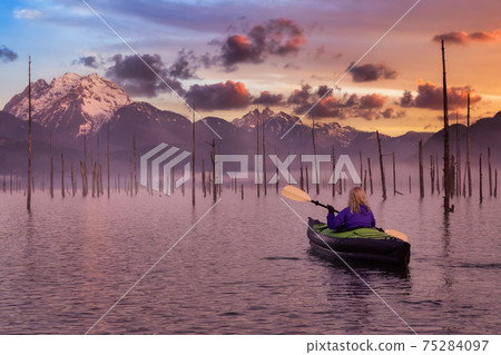 Adventurous Girl kayaking on an infatable kayak in a beautiful lake 75284097