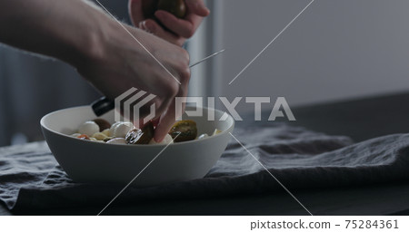 put kumato tomatoes on fettuccine in white bowl on linen cloth put kumato tomatoes on fettuccine in white bowl on linen cloth 75284361