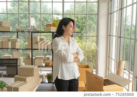 Asian business woman with postal parcel packaging carton box delivery, working from home, selling products online business. Shipping service. People lifestyle in coronavirus pandemic. SME ecommerce 75285008