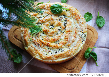 Homemade baked goods with a crispy crust meat pie on a wooden cutting board 75286910
