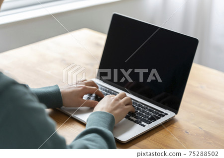 Hand of a young man operating a laptop 75288502