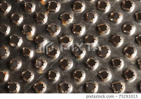 Close-up pattern of the holes of an old kitchen grater with rust elements. Grunge background 75291013
