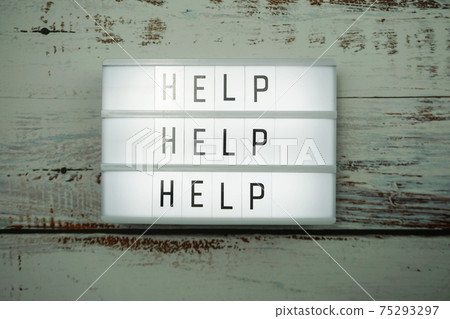 Help word text in light box on wooden background Help word text in light box on wooden background 75293297