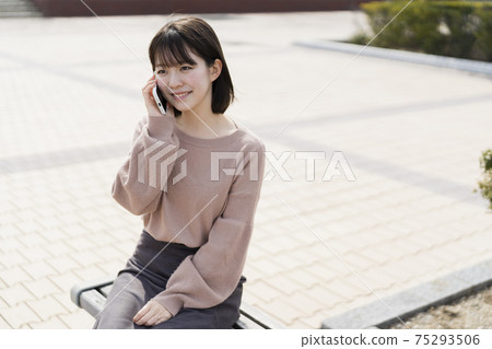 使用智能手機的婦女在公園 使用智能手機的婦女在公園 75293506
