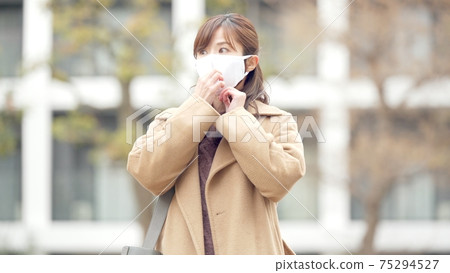 Woman taking out a mask from the mask pouch Woman taking out a mask from the mask pouch 75294527
